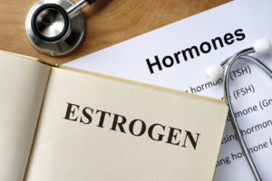 A book's heading says, "Estrogen." A piece of paper underneath the book says, "Hormones."