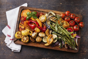 A cutting board holds sauteed and grilled vegetables.