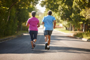 A man and woman jog outside together.