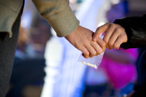 A kid hands someone a plastic bag with an ADHD drug. 