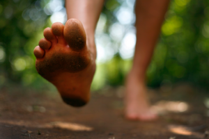 A person walks outside barefoot.