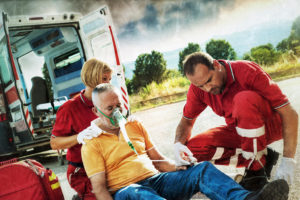 A person is being prepared to enter an ambulance post-car accident.