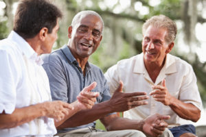 A group of elderly men laugh together.
