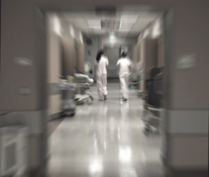 Two medical professional walk through a hallway during their night shift.