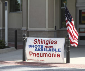 A sign says, "Shingles shots now available. Pneumonia."