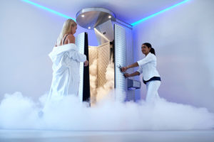 A woman walks into a body cryotherapy machine.