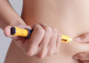 A person gives themself an injection to improve their blood sugar levels.