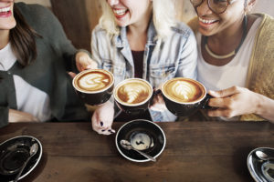 A group of friends enjoy coffee together at a coffee shop.
