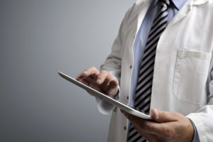 A doctor holds an electronic tablet.
