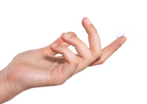 A person holds a contact lens on their finger.