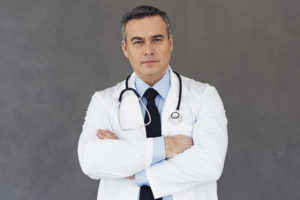 A doctor crosses their arms and poses for a photo.