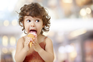 A kid eats ice cream.