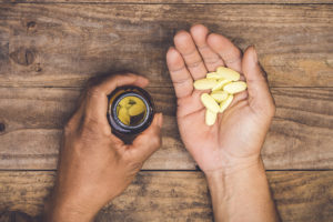 A person fills their hand with multivitamins.