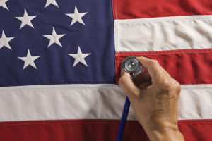 A person places a stethoscope on an American flag.