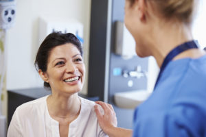 A woman smiles at a medical professional.