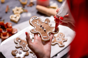 A person decorates gingerbread cookies.