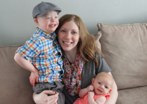Melissa Finkbeiner sits on a couch with her son and baby daughter.