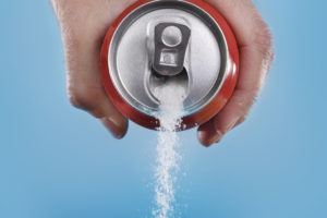 A soda can pours out sugar.