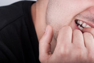 A person bites their fingernails.