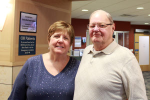 Janice Covey and her husband, Roger Lobert, pose for a photo and smile.