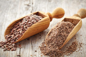 Two wooden scoops hold flaxseed.
