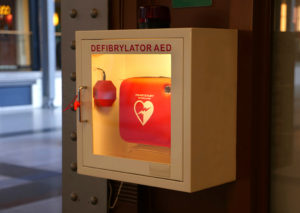 An automated external defibrillator (AED) is in focus.