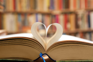 A book is open and two of its' pages are folded together to shape a heart.