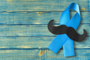 A blue ribbon, symbolizing prostate cancer, is shown.