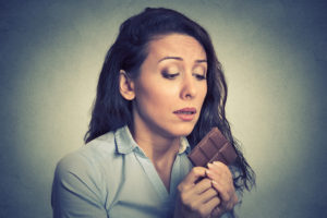 A woman stares deeply at chocolate.