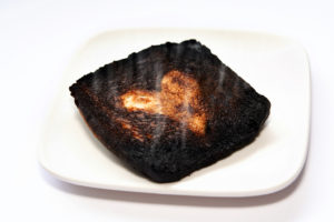 A burnt piece of toast is in focus.
