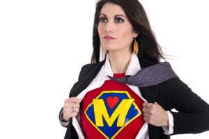 A woman opens her suit to revel a colorful T-shirt with a letter M on it.