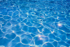 A blue swimming pool is in focus.