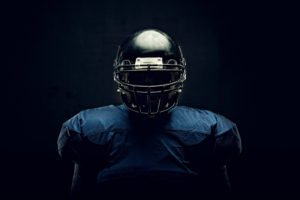 A football player in their uniform poses for a portrait.