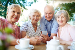 A group of elderly adults pose for a photo and smile.