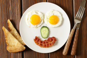 A white plate is shown with eggs, bacon and toast.
