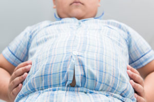 A young boy looks down at his stomach.
