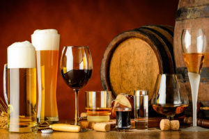 Multiple glasses are shown filled with beer or wine.