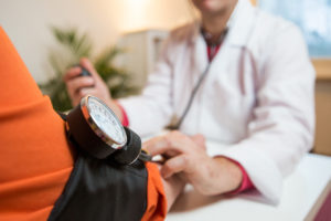 A person gets their blood pressure measured by a medical professional.