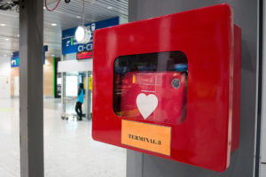 An automated external defibrillator (AED) hangs on a wall.