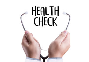 Two hands hold a stethoscope's ear pieces to, what reads, "Health Check."