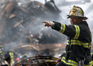A firefighter points his finger and shouts away from an extinguished hazardous fire.