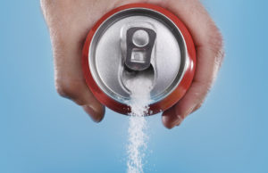 A person pours a pop can that pours out sugar.