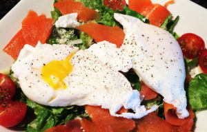 A salad with salmon, tomatoes and eggs.
