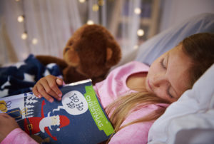 A child falls asleep reading a bedtime story.