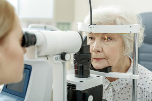 An elderly woman receives an eye test.