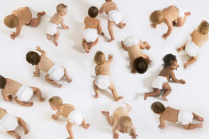 A group of babies crawl together.