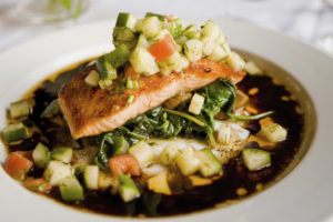 A plate with salmon and vegetables.