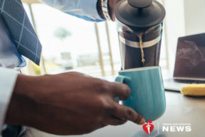 A person pours coffee into a blue mug.