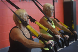 Two women work out together and smile.
