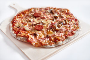 A pepperoni pizza is in focus.